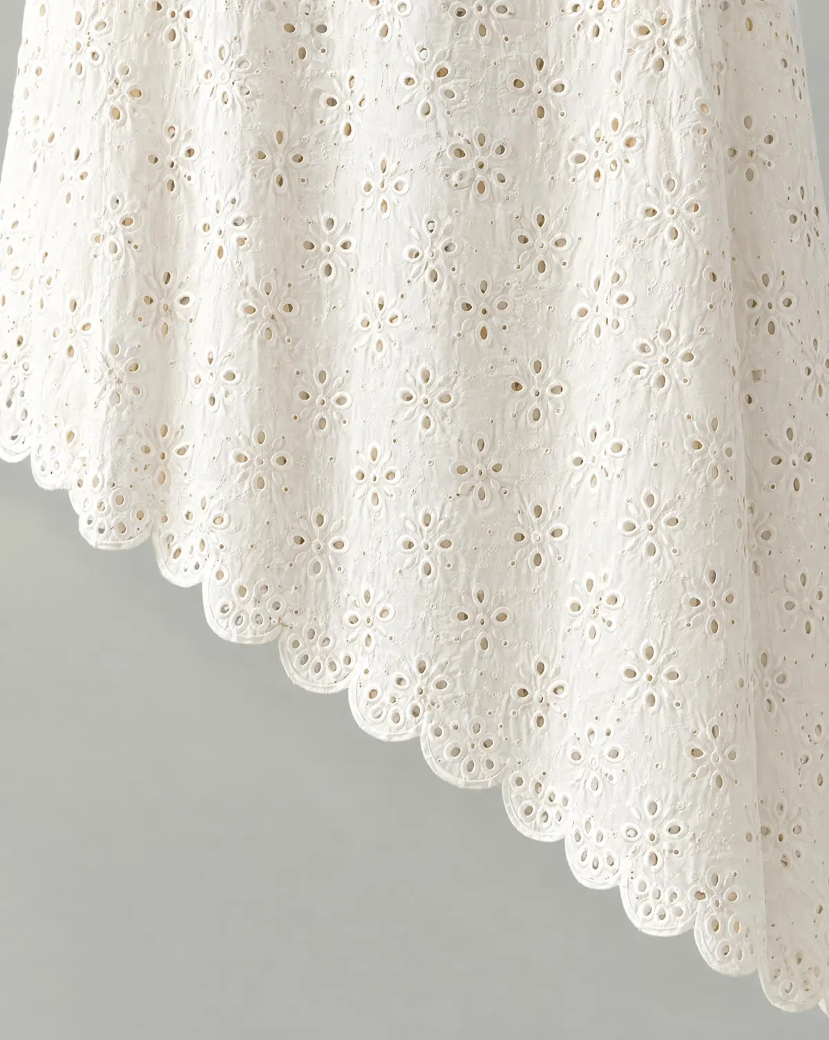 Close-up of the asymmetric scallop skirt embroidery and finishing