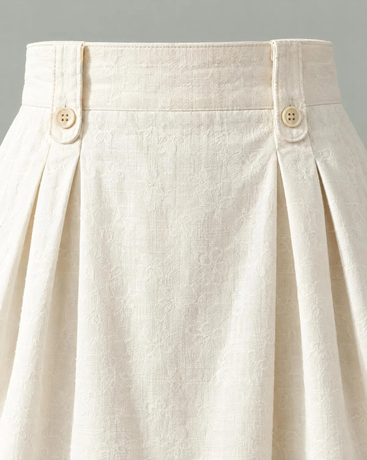 Close-up of the button-tab pleat skirt embroidery and finishing