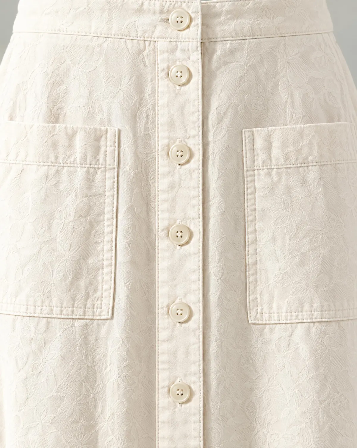 Close-up of the button-through midi skirt embroidery and finishing