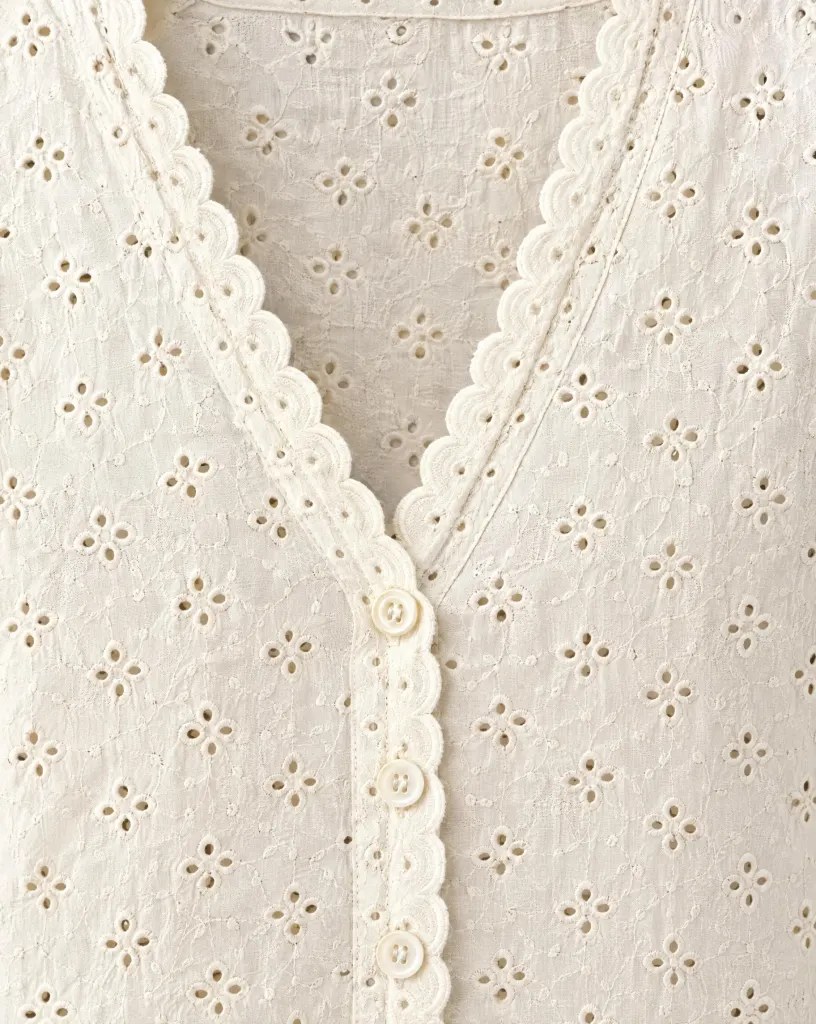 Close-up of the scallop-edge button layer embroidery and finishing